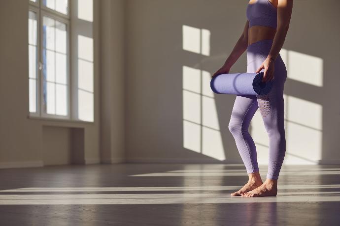 Femme qui déplie son tapis de yoga