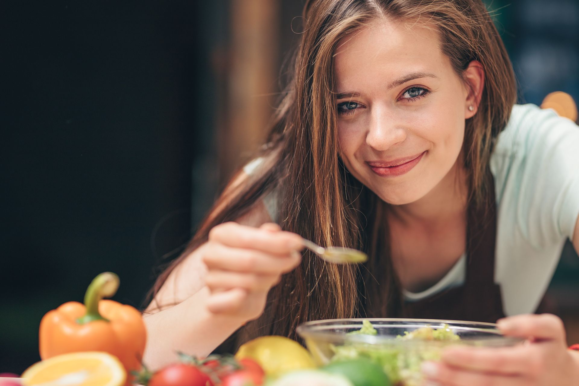 Jeune femme souriante occupée à déguster une salade