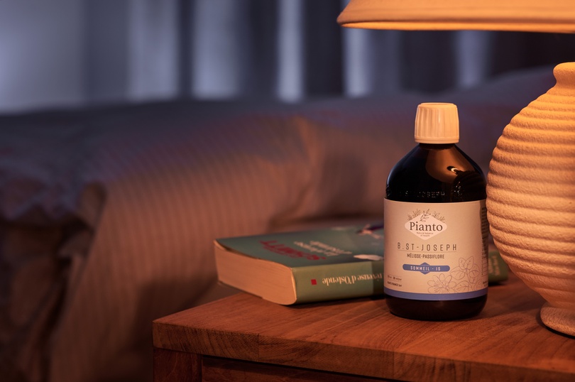 Bouteille de B.St-Joseph Sommeil à sur une table de nuit avec un livre