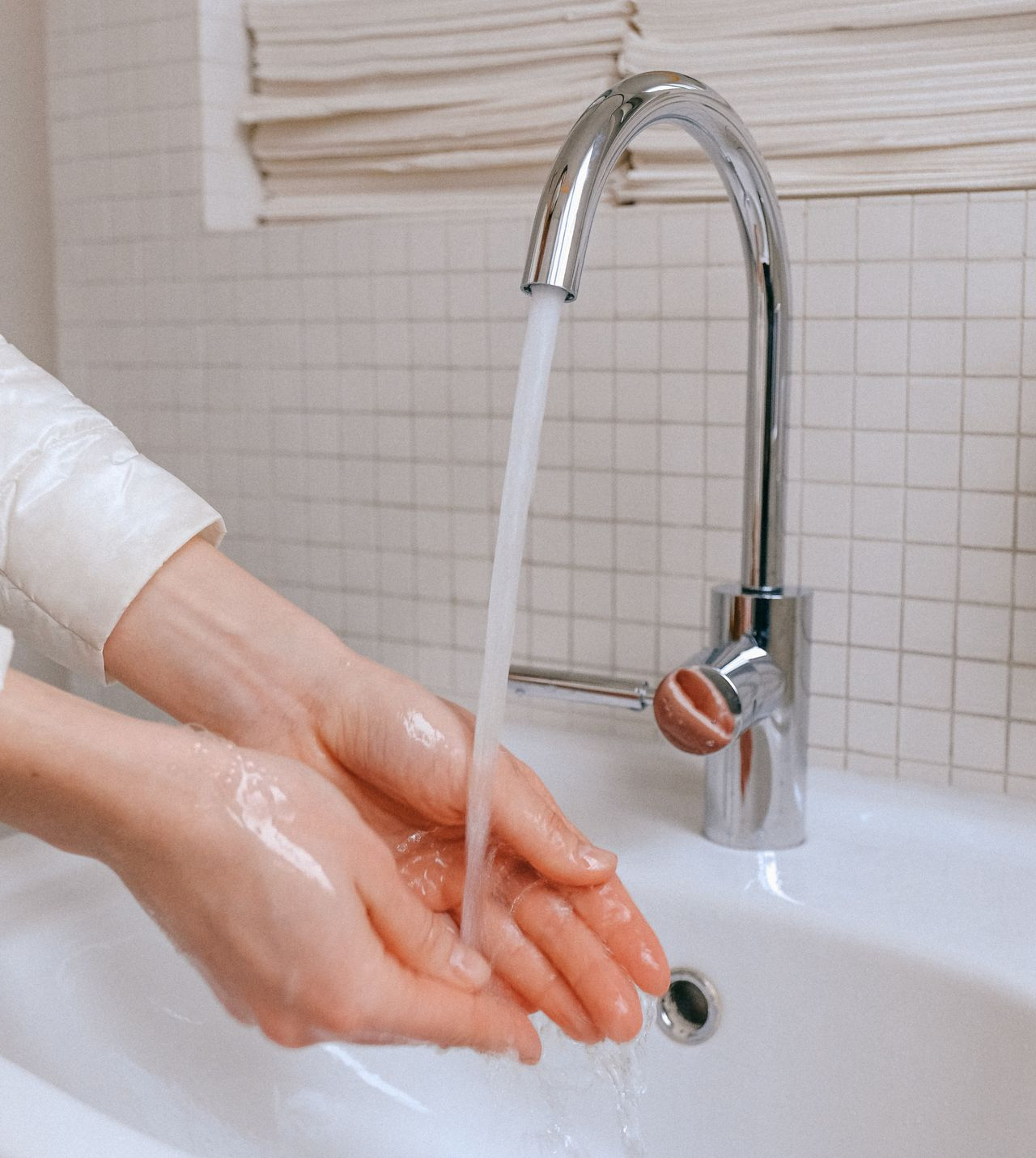 Mains occupées à être nettoyées sous l'eau du robinet 