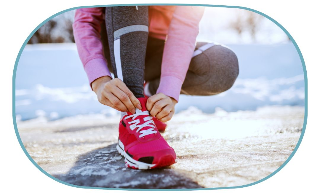 Personne sportive occupée à lacer ses chaussure de sport dans la neige