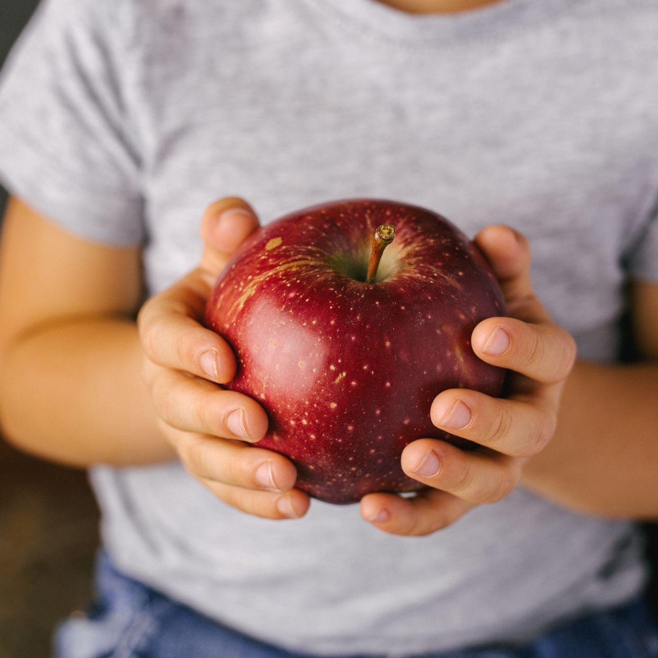 Pomme dans les mains d'un enfant 