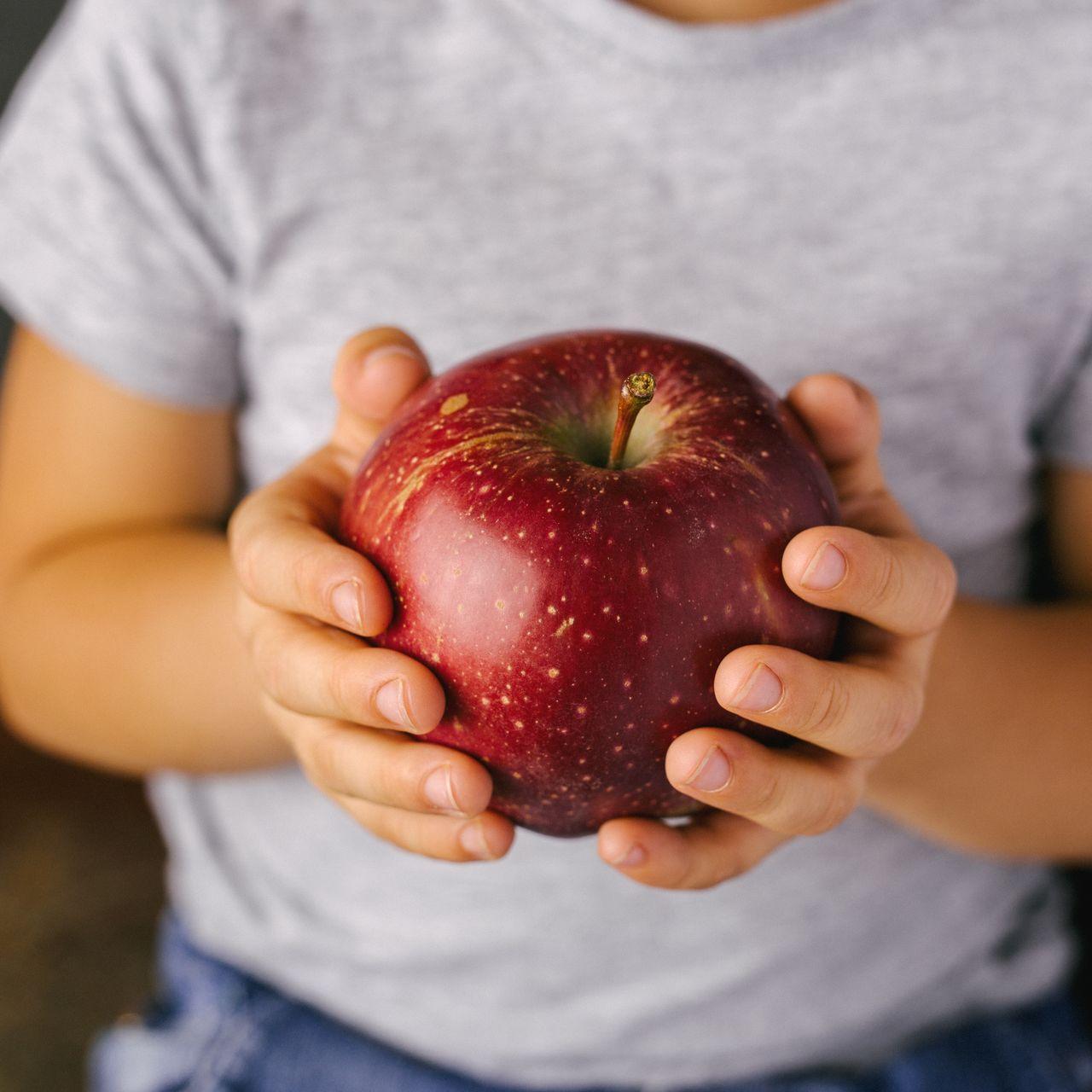 Pomme dans les mains d'un enfant