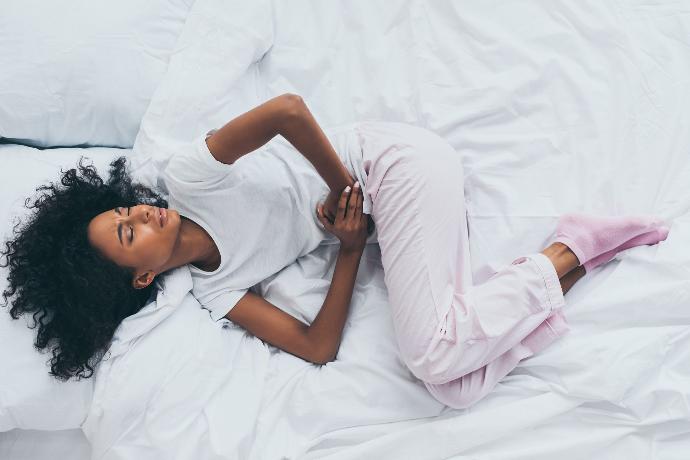 Femme allongée qui a mal au ventre